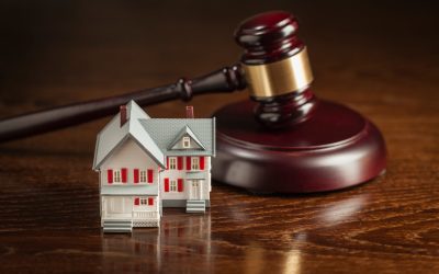 Gavel and Small Model House on Wooden Table.